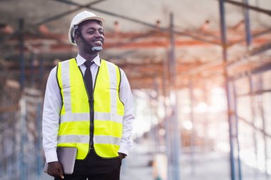 Afrikalı mimar ve tablet mühendisi inşaat alanında birlikte çalışıyorlar. Mühendislik kavramları ve teknolojik uygulamalar.