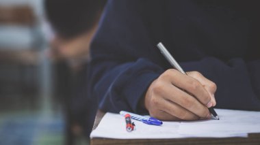 Sınav kağıtlarını okuyan ve alan öğrencilerin el kapaklarını kapatın sınıfta stres ile cevap verin