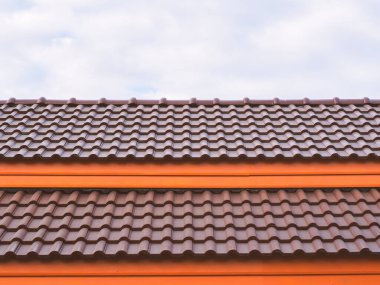 Mavi gökyüzü olan yeni evin üzerinde turuncu kiremit çatı