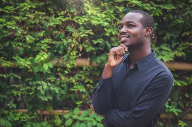 Afrikalı adam ellerini çapraz yapıp dostça gülümsedi. Siyah adam Afrika 'nın kırsal kesimindeki geleceğini olumlu olarak düşünüyor.