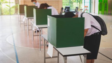 Öğrenciler oy pusulasını kullanarak okul içinde oy veriyorlar. Okul içinde temel demokrasi kavramı.