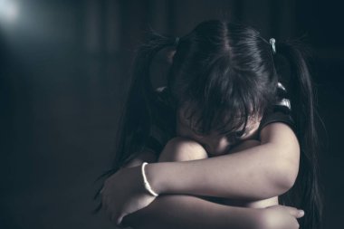 Ne yazık ki küçük kız karanlık bir odada yalnız oturuyor.