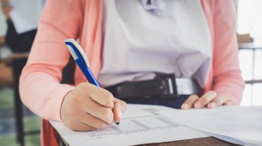 Öğrenciler sınavları sınıfta stresli bir şekilde yapıyorlardı. Lise öğrencilerinin değerlendirme sınavı.