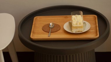 Metal kaşıklar ve beyaz kremalı kekler masaya konur..