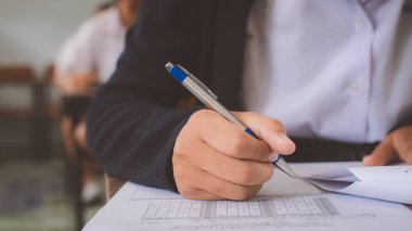 Sınav kağıtlarını okuyan ve alan öğrencilerin el kapaklarını kapatın sınıfta stres ile cevap verin