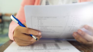 Sınav kağıtlarını okuyan ve alan öğrencilerin el kapaklarını kapatın sınıfta stres ile cevap verin