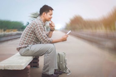 Asyalı gezgin, tren saatleri, turistik yerler ve tatil yerleri hakkında bilgi edinir