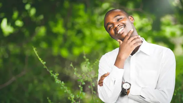 Hombre Africano Con Una Camisa Blanca Sonríe Felizmente Ambiente Natural —  Fotos de Stock