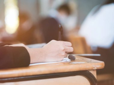 Sınav kağıtlarını okuyan ve alan öğrencilerin el kapaklarını kapatın sınıfta stres ile cevap verin