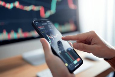Kapanış grafiği - Kadın akıllı telefon, kripto para birimi gelecek fiyat öngörüsünde Bitcoin fiyat tablosunu kontrol ediyor.