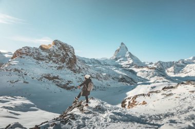 Sırt çantalı mutlu gezgin kadın İsviçre Alplerinde kışın Matterhorn ile eğleniyor, Avrupa seyahati