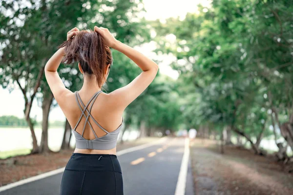 아시아의 스포츠 여성은 공원에서 운동할 준비가 포니테일을 만들기 머리를 묶는다 — 스톡 사진