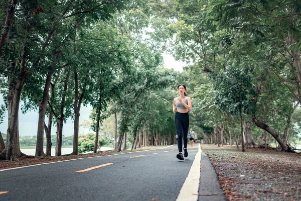 午前中に公園を走っている健康なアジアの女性ランナー 健康的なライフスタイルのコンセプト — ストック写真