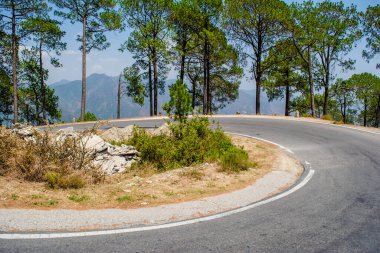 Beautiful  curvy Road on the mountains of Lansdowne, Uttarakhand. Aerial view of amazing curved road through the mountains. clipart