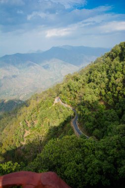 Beautiful  curvy Road on the mountains of Lansdowne, Uttarakhand. Aerial view of amazing curved road through the mountains. clipart