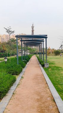 Parkın kenarındaki parkta koşmak ya da yürümek için yol ve pist. Parkta mavi gökyüzü ile güzel bir yol.