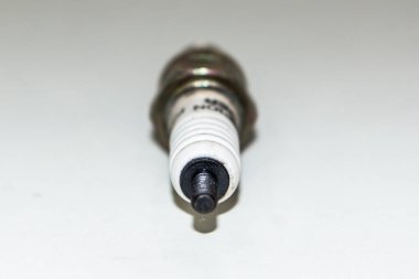 İzole edilmiş beyaz bir arka planda arabalar ve bisikletler için buji. Bakır bujiler. Aşınmış elektrotlu bujiler. Seçici odaklanma. Elektriksel ateşleme parçaları.