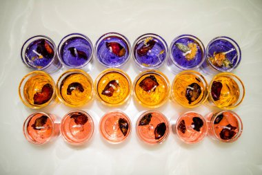 Beyaz arka planda izole edilmiş cam jel mum. Renkli jel mumlar. Camda mum ve bir sürü renkli mum..