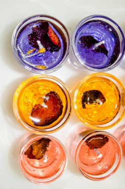 Beyaz arka planda izole edilmiş cam jel mum. Renkli jel mumlar. Camda mum ve bir sürü renkli mum..