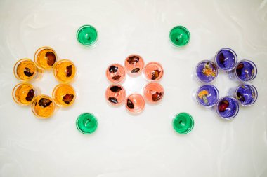 Beyaz arka planda izole edilmiş cam jel mum. Renkli jel mumlar. Camda mum ve bir sürü renkli mum..