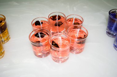 Beyaz arka planda izole edilmiş cam jel mum. Renkli jel mumlar. Camda mum ve bir sürü renkli mum..