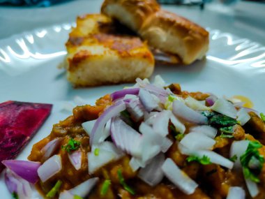 Mumbai Style Pav Bhaji, Indian spicy fast food with bread, onion and butter. Pav bhaji is a fast food dish from India consisting of a thick vegetable curry served with a soft bread roll clipart