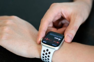 Young Man's hand with Apple Watch Series 8 measuring heart rate. Apple Watch was created and developed by the Apple inc. clipart