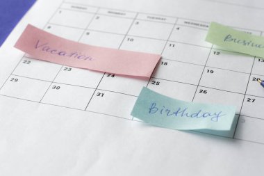 Yapılacak faaliyetleri vurgulamak için ayın takvimi ve çok sayıda renkli yapıştırıcı notları. Uzayı kopyala Zaman organizasyonu kavramı ve hedeflerin gerçekleştirilmesi.