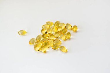 Beyaz arka planda morina yağı vitamini ve yumuşak jel kapsülleri