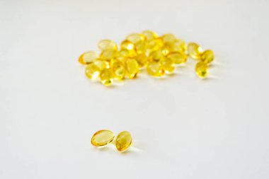 Beyaz arka planda morina yağı vitamini ve yumuşak jel kapsülleri
