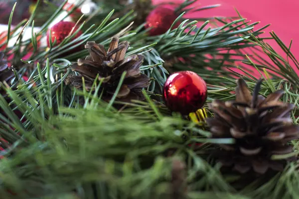 Geleneksel yeşil arka plan ve kırmızı Noel topları ve ladin konisi