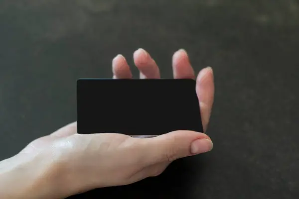 Siyah kart şablonlu bir kadın eli