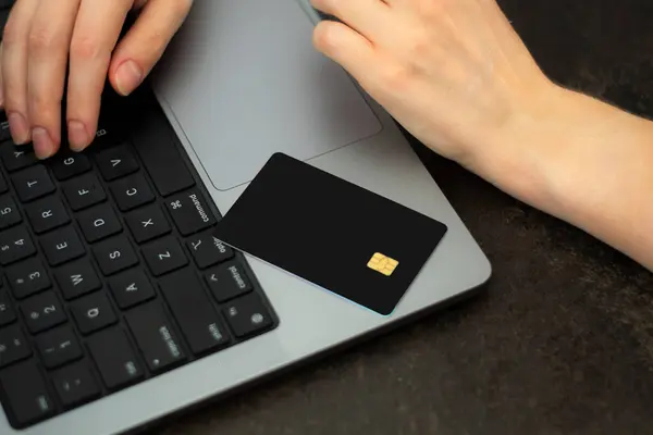 Müşteri, sahibine ödeme yapmak için kredi kartını kullanıyor. Nakitsiz teknoloji ve kredi kartı ödeme konsepti. İnternet üzerinden kolaylık sağlamak için. Laptopta siyah kredi kartı. premium banka konsepti