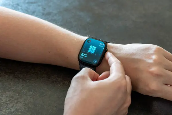 San Francisco, ABD - 4 Ekim 2024: Apple Watch Serisi 10 günlük aktiviteleri kontrol eden genç adam. Apple Watch Apple tarafından yaratıldı ve geliştirildi..