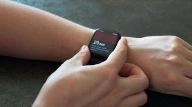 Elma Saati Serisi 10 kalp atış hızını ölçen genç adamın eli. Apple Watch Apple tarafından yaratıldı ve geliştirildi..