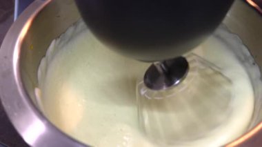 Yemek işleyicisi kek hamurunu metal bir kaseye karıştırıyor. Karıştırıcı hamur, kek ya da kek pişirir, yavaş çekimde kapatır.