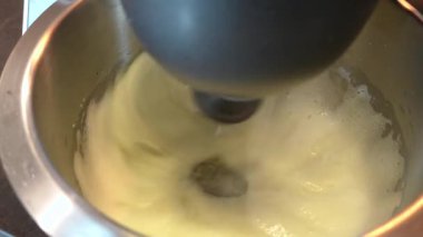 Yemek işleyicisi yumurta proteinini metal bir kasede çırpar. Karıştırıcı yumurta beyazı ve şekeri kalın bir köpükle çırpıyor, kek veya kek pişiriyor, kapat.