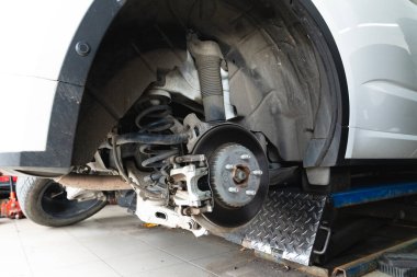 Arabanın arka tekerinin lastik değiştirmesinin ayrıntıları. Araba tamirhanedeyken asılıydı..