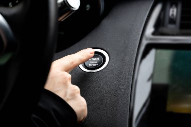 Kadınlar motoru çalıştırmak ve durdurmak için düğmeye basıyor, modern spor arabalarda motoru çalıştırma düğmesine basıyor