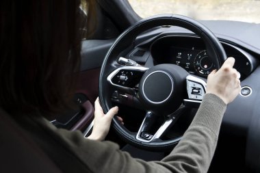 Direksiyondaki genç kadın araba kullanıyor. Arka plan görünümü yatay resmi.