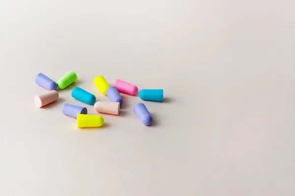 Pastel arka planda renkli kulak tıkaçları