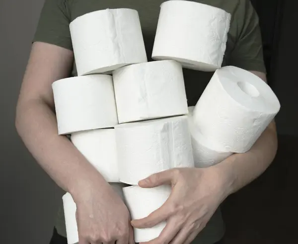 Adam ev için tuvalet kağıdı stokluyor. Bir sürü tuvalet kağıdı tutuyor.