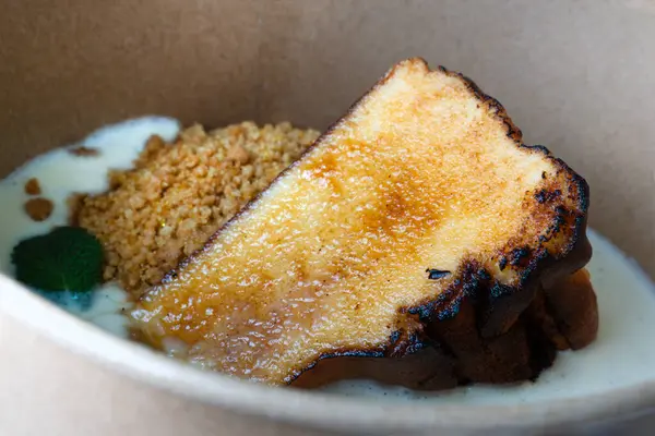 Karton kasede yanmış bir dilim Bask peynirli kek, yiyecek teslimatı, geleneksel tatlı.