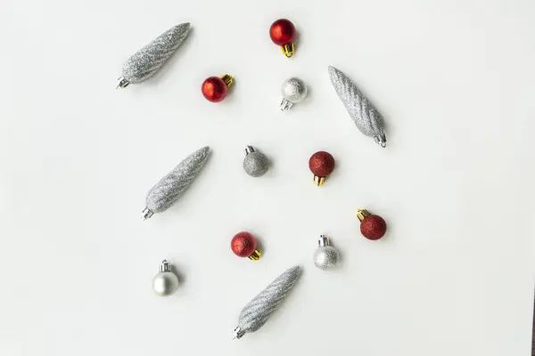 Kırmızı ve beyaz Noel ağacı süslemeleri beyaz zemin üzerinde gümüş pullar ve fotokopi alanı