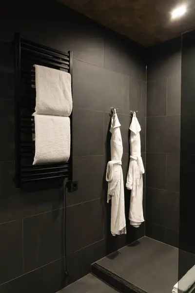 Çiftler için bornoz banyodaki siyah duvara asılacak.