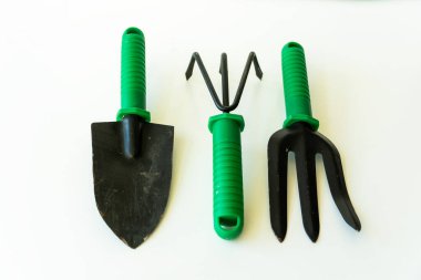 Beyaz arka planda bahçe aletleri. Bahar bahçesi konsepti. Dünya Çevre Günü, Ağaç Bayramı, Üst Manzara Tırmık, Kürek ve Yaba,