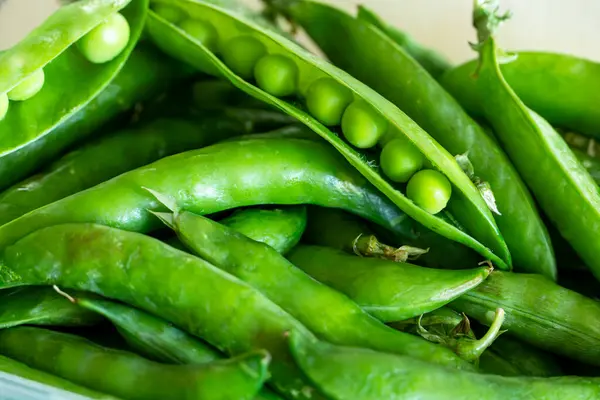 Birçok taze bezelye kabukları arka planı kapatır,