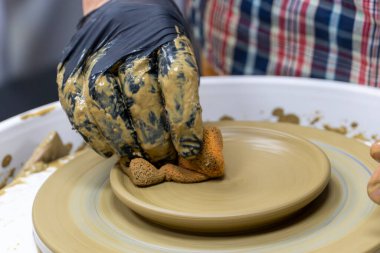 Çömlekçilik dersinde seramik kase yaratmak. Tekerlek atma. Çömlek tekeriyle kilin farklı şekillerde nasıl modelleneceğini öğrenmek