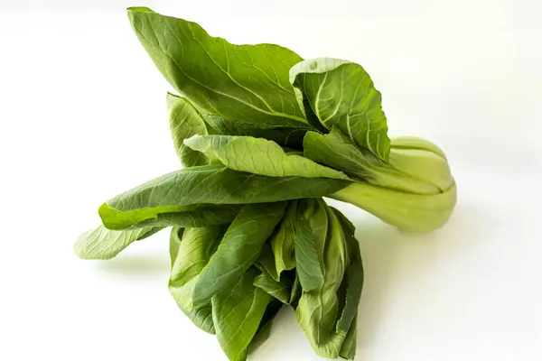 Taze Pak Choi lahanası, taze yeşil yapraklar ve beyaz saplı, beyaz arka planda izole. Asya mutfağı, kızartma, salata ve sağlıklı vejetaryen yemek kavramları..