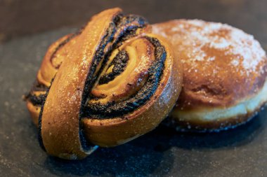 Haşhaş tohumu ile taze pişmiş tatlı çörek ve şeker kaplı kremalı çörek, geleneksel fırın tatlıları..